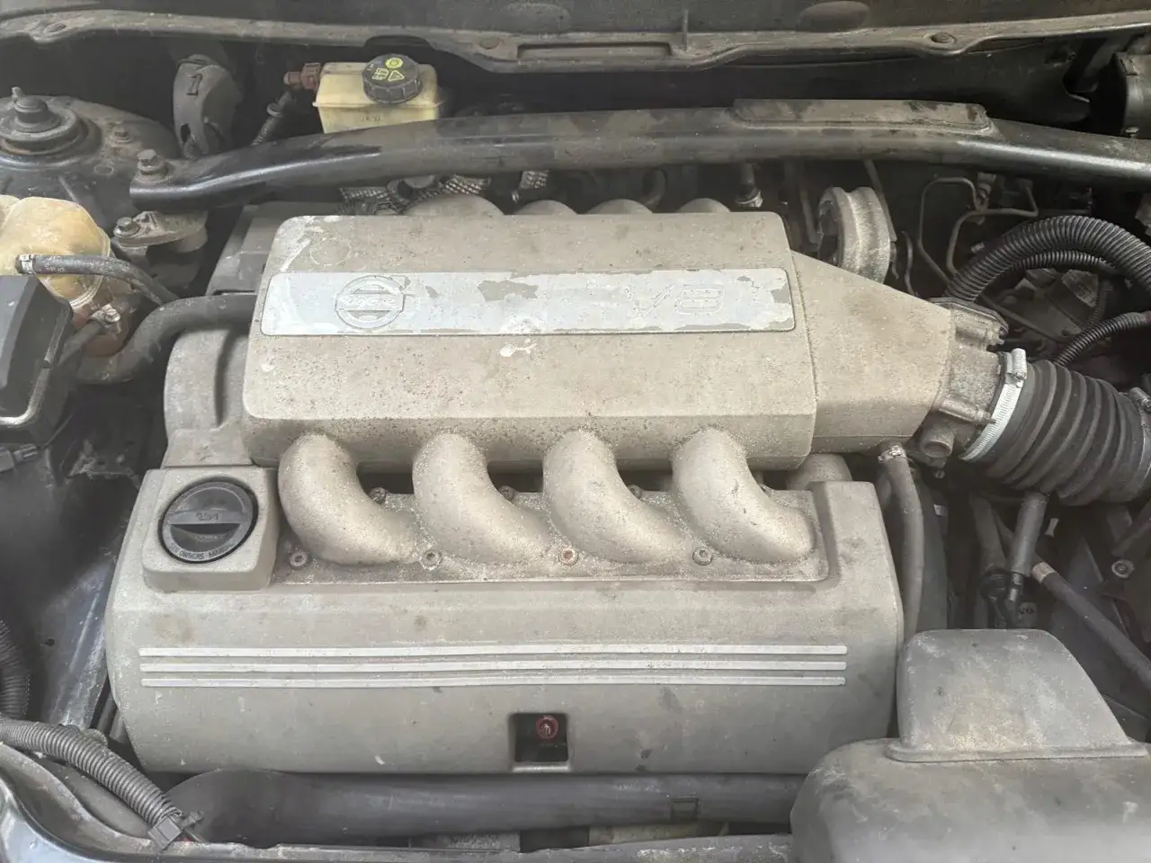 Silnik V8 Volvo, pokryty kurzem, z widocznym logo Volvo i oznaczeniem V8.