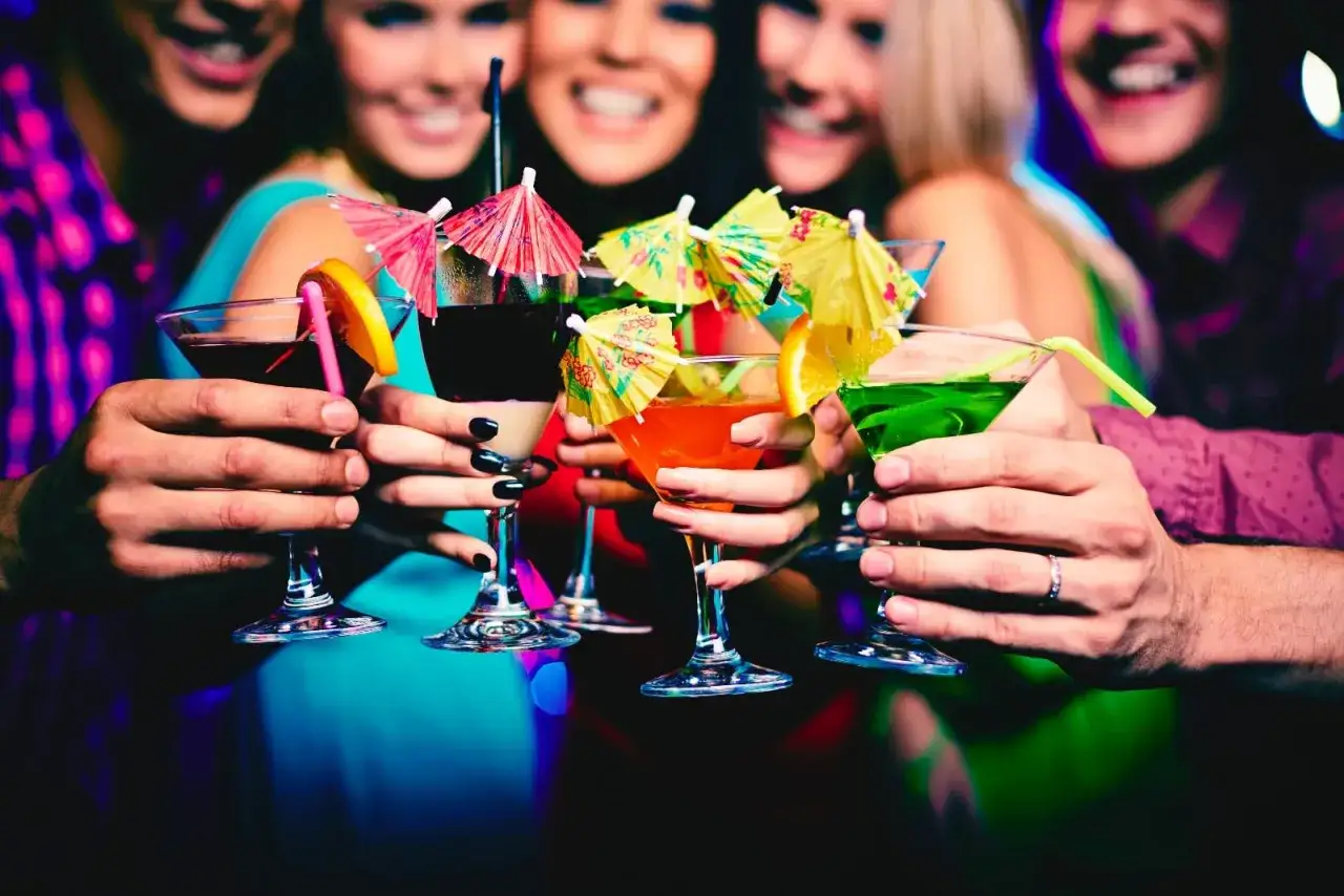 Brindisi con cocktail colorati, sorrisi e luci soffuse: la movida di Monaco di Baviera in piena festa.