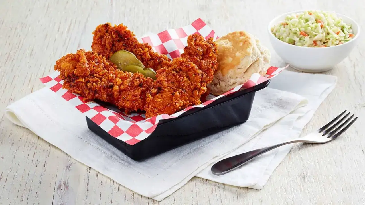 Chrupiące strips KFC, idealne na szybki posiłek. Zastanawiasz się nad kcal? Obok znajduje się bułeczka i surówka coleslaw.