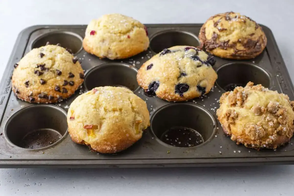 Sallys Muffins: Schoko-Chips, Blaubeeren, Streusel und Fruchtstücke in einer Muffin-Form.