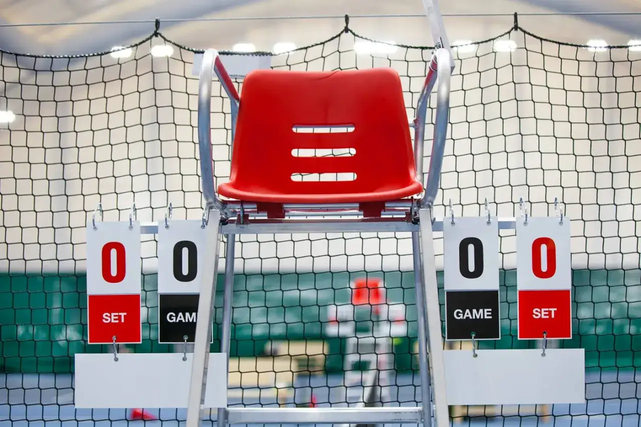 Sędziowskie krzesło na korcie tenisowym, tablice wynik&oacute;w pokazują 0:0. Czas na grę, kto zdobędzie przewagę w tenisie?
