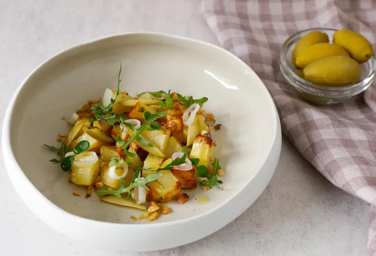 Un'appetitosa insalata di patate pugliese, arricchita da rucola fresca, cipolla rossa e croccanti pezzetti di pane.