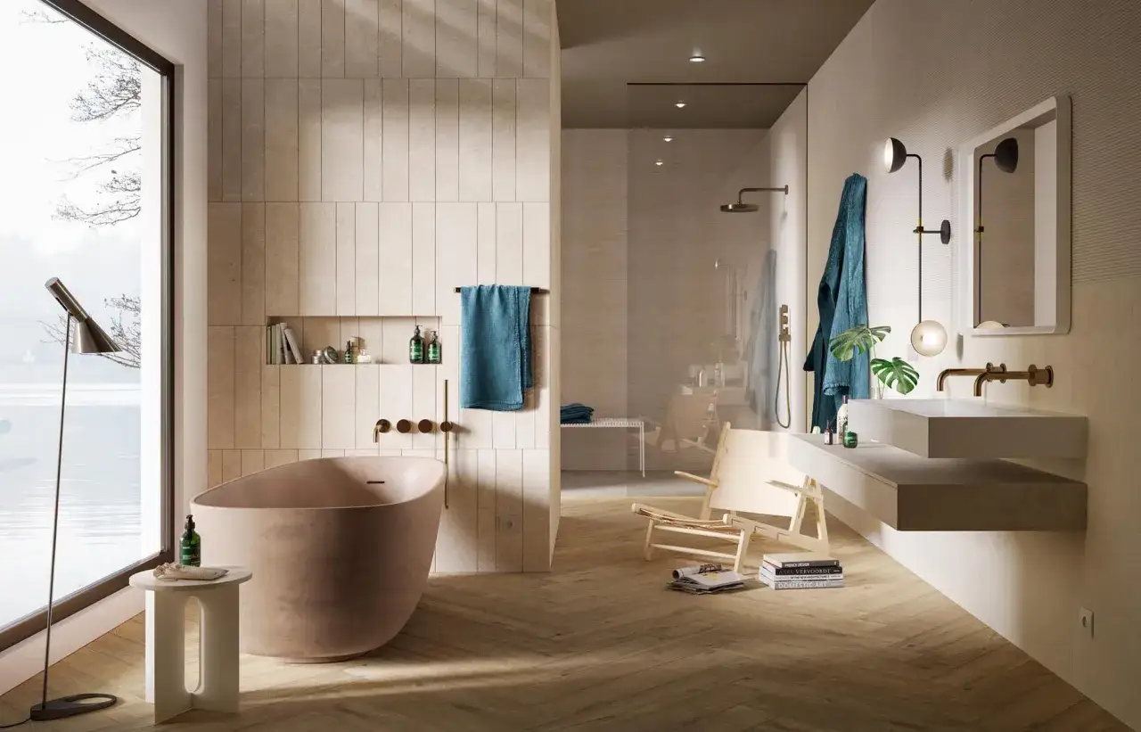 &Eacute;l&eacute;gante salle de bain beige et blanc avec baignoire, douche vitr&eacute;e, lavabo suspendu et vue sur l'eau.