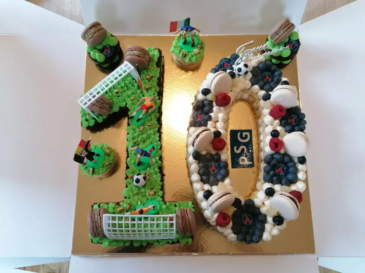 Un spectaculaire number cake 10 ans sur le th&egrave;me du football, d&eacute;cor&eacute; de macarons, fruits et figurines de joueurs.