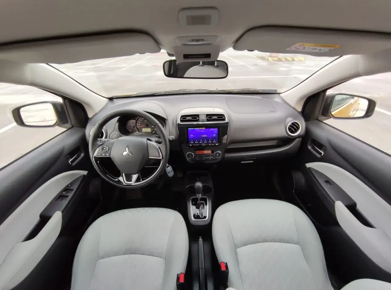Wnętrze Mitsubishi Space Star: kierownica, deska rozdzielcza z ekranem multimedialnym i jasne siedzenia.