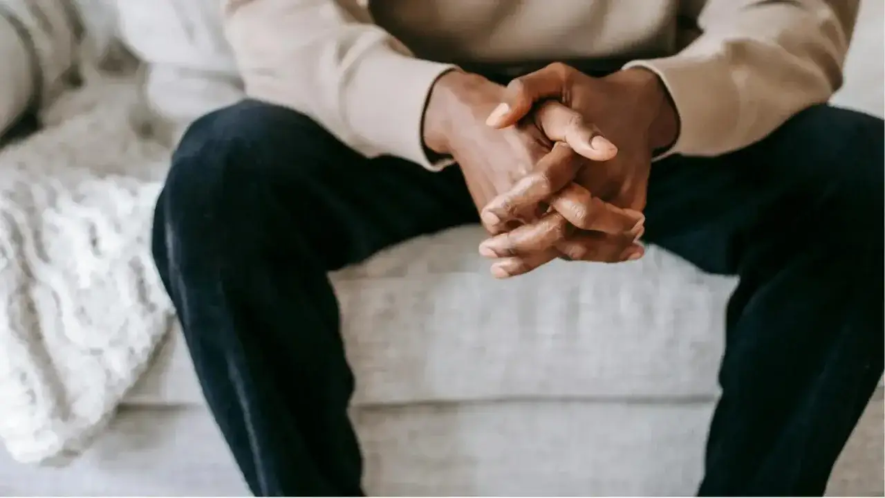 Homme assis, mains jointes, pensif. Il pourrait r&eacute;fl&eacute;chir &agrave; un besoin sexuel homme, ou &agrave; tout autre d&eacute;sir profond.