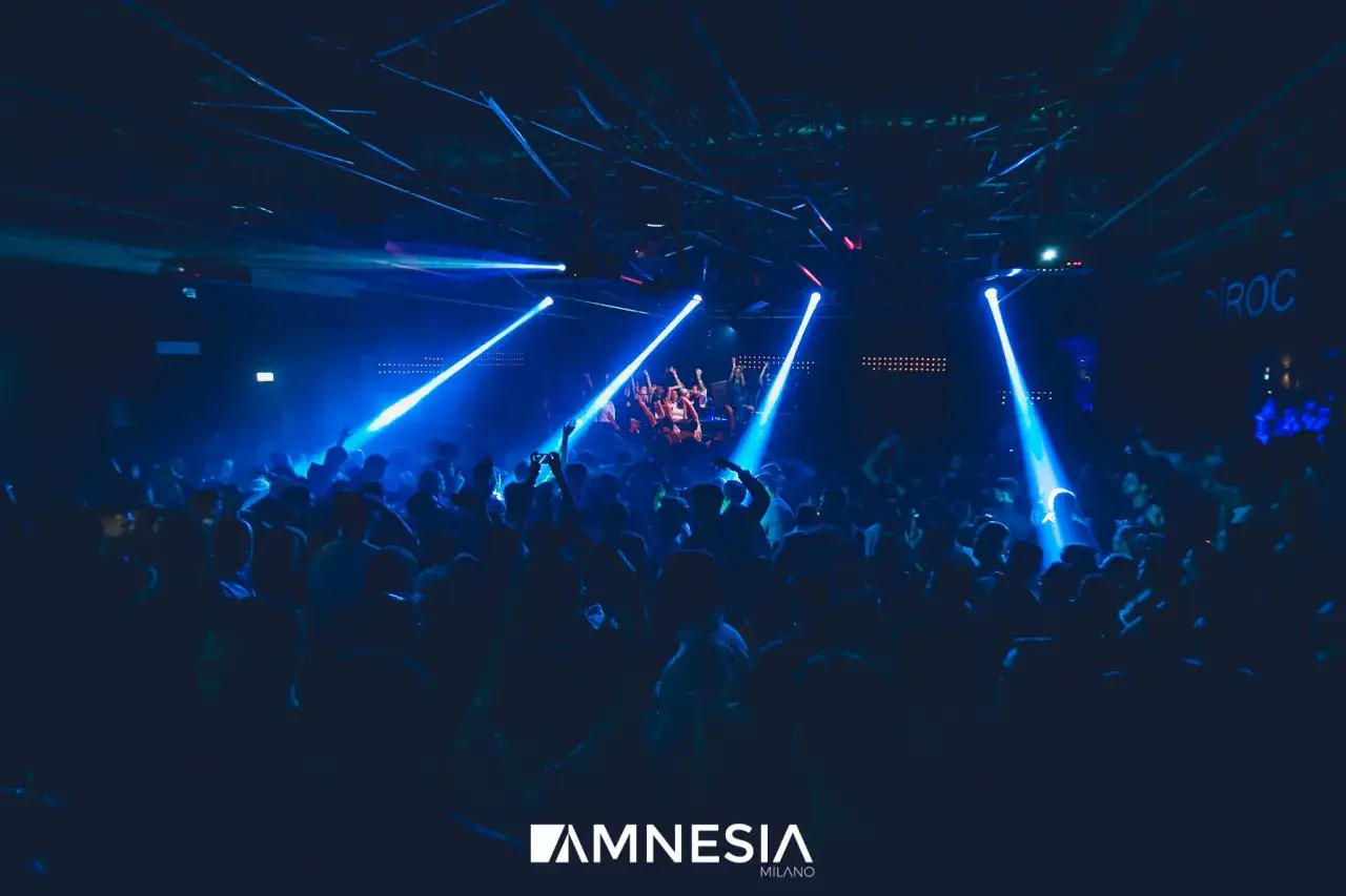 Folla in delirio all'Amnesia Milano, luci blu e musica pulsante. Le recensioni confermano: un'esperienza indimenticabile.