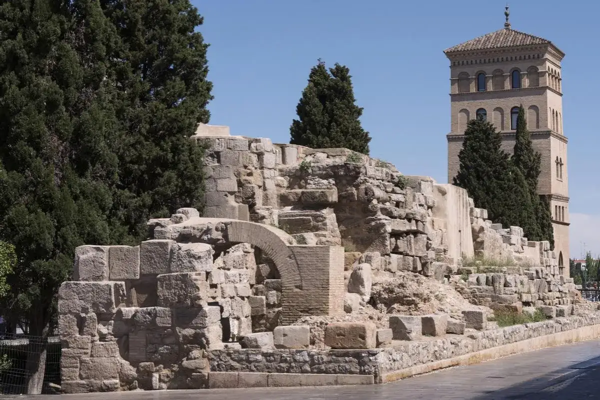 Ruinas romanas en Zaragoza, con una torre mudéjar al fondo. Un lugar para explorar la historia de los museos romanos Zaragoza.