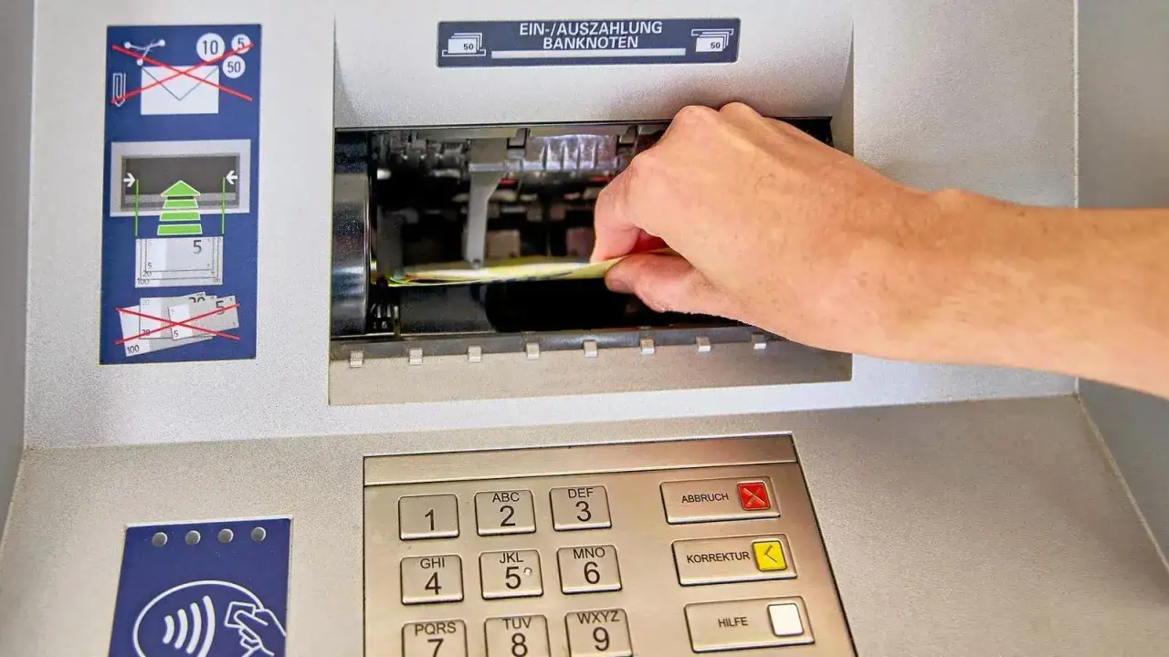 Eine Hand f&uuml;hrt Geldscheine in einen Geldautomaten ein, um Geld einzuzahlen. Die Anleitung zeigt, welche Banknoten akzeptiert werden.