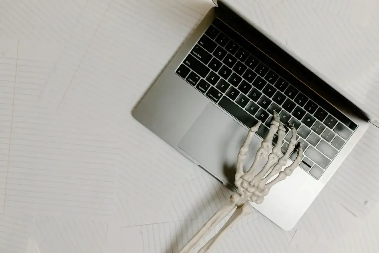 Szkielet pisze na klawiaturze laptopa. Może to symbolizować potrzebę naprawy keyboard&oacute;w, gdy praca staje się tak męcząca, że nawet kości się odzywają.