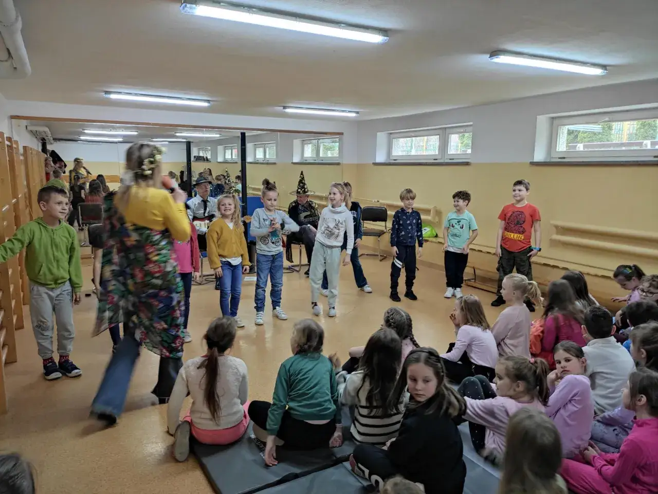 Dzieci słuchają występu muzycznego. Czy to muzyka do której klasy?