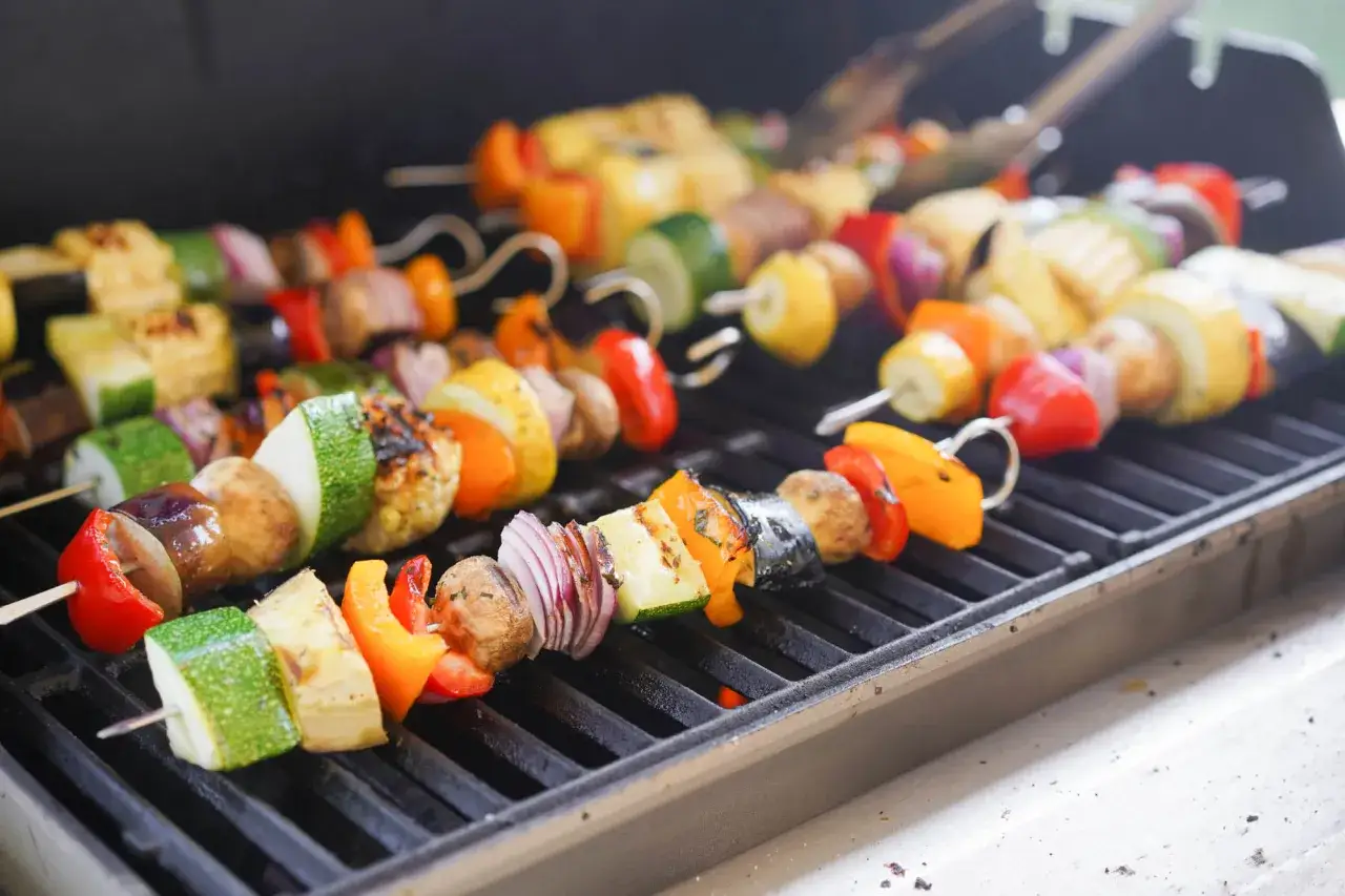 Kolorowe szaszłyki z warzywami, takie jak papryka, cukinia i cebula, grillują się na ruszcie. To pyszny, letni gemüse kebab.