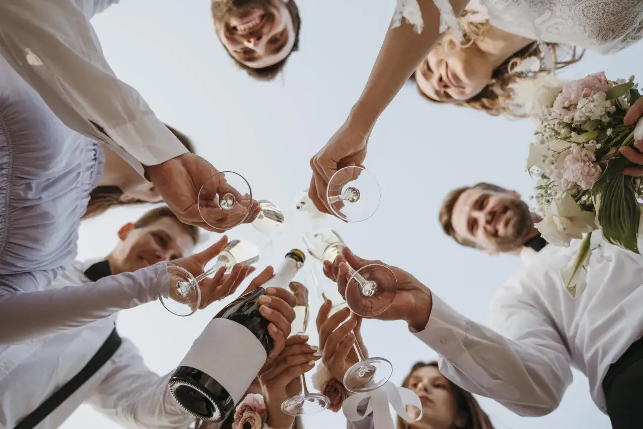 Różnica między poprawinami a wspólnym śniadaniem dla gości: toast szampanem z bliskimi, uśmiechy i bukiet panny młodej.