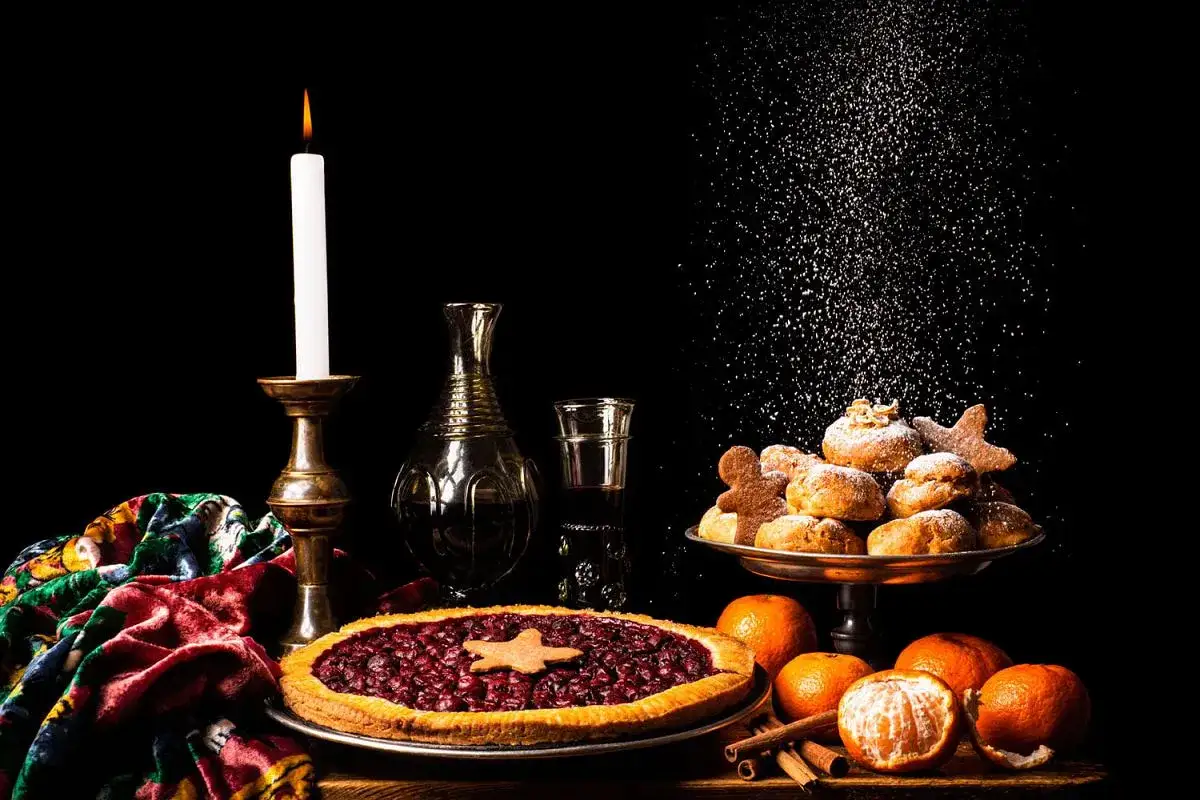 Gdański bowke menu: świeca, ciasto z wiśniami, pierniczki i mandarynki.