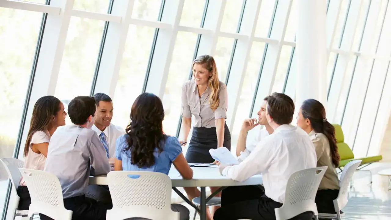 A diverse team collaborates in a bright meeting room, discussing how to improve company culture.