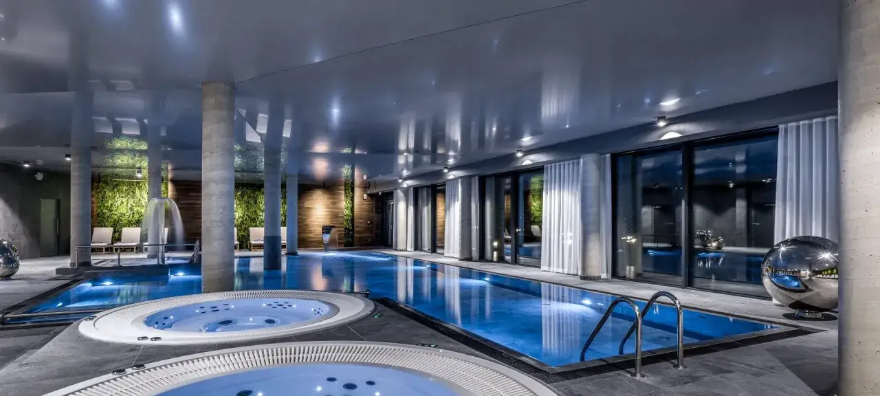 Nowoczesny basen z jacuzzi i kaskadą, idealny dla szukających najlepszych hoteli w g&oacute;rach.