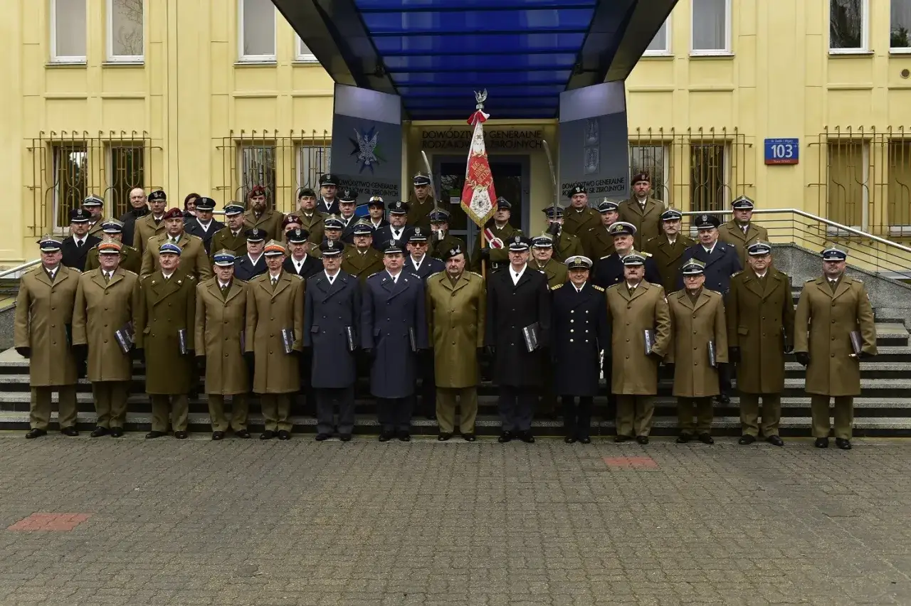 Grupa oficerów w mundurach przed budynkiem Dowództwa Generalnego Rodzajów Sił Zbrojnych. W centrum stoi dowódca generalny rodzajów sił zbrojnych.