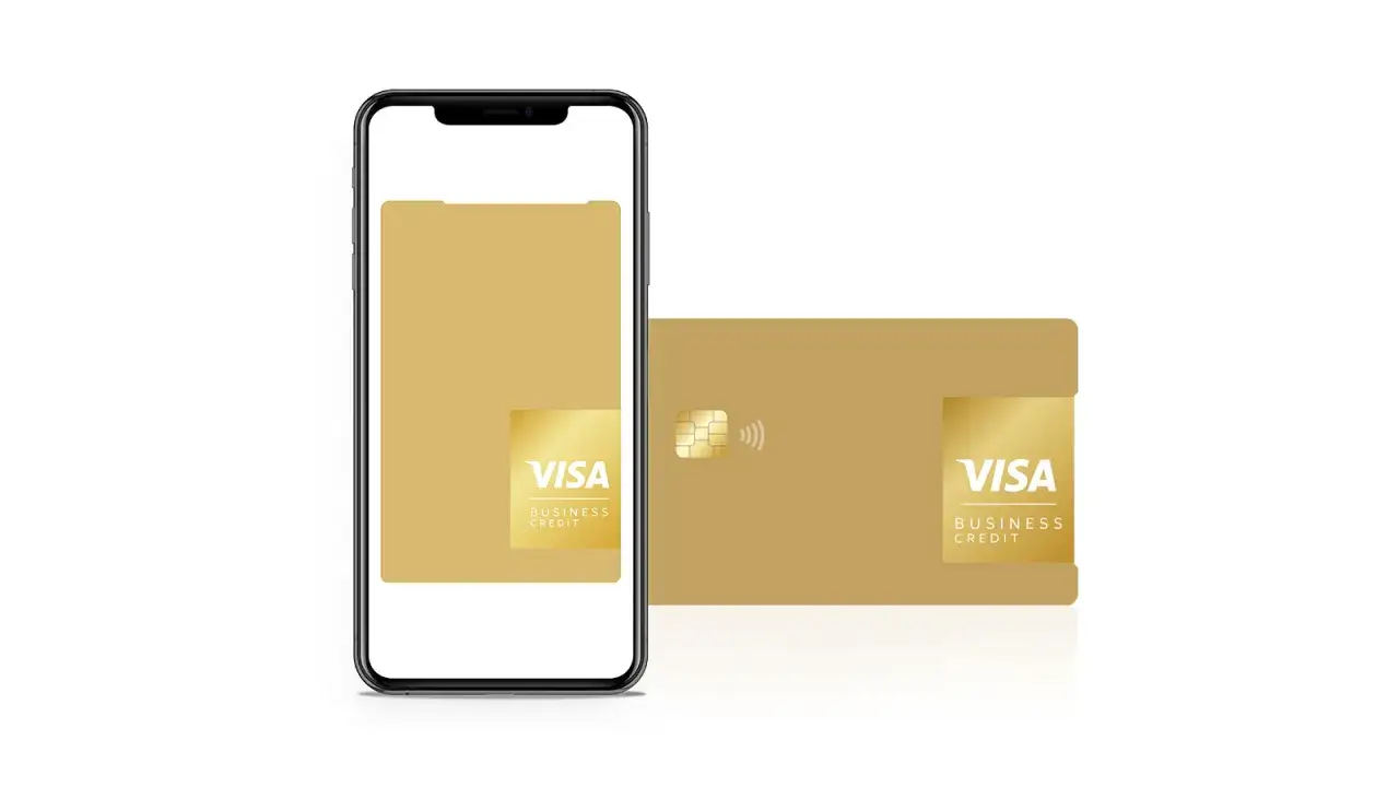 Złota karta prepaid Visa Business Credit obok smartfona.