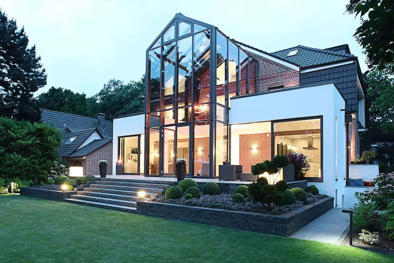 Moderner Anbau an altes Haus mit Glasfront und Blick auf den Garten.