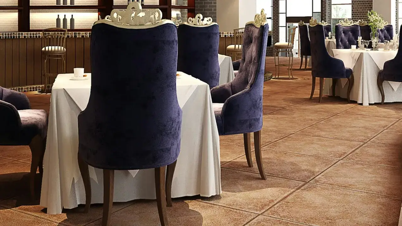 Mesas vestidas y sillas de terciopelo púrpura, un ambiente que evoca nombres de restaurantes elegantes.