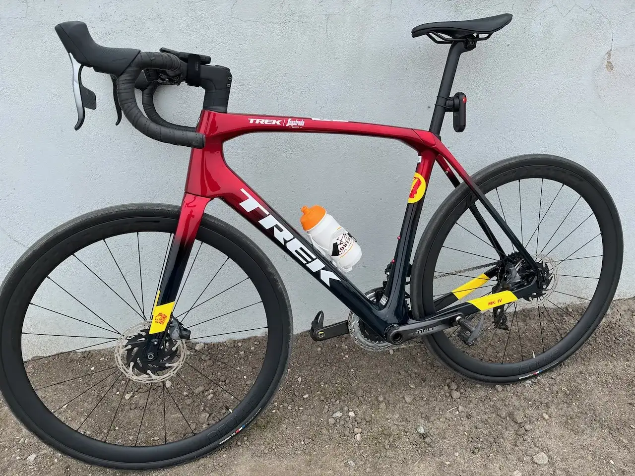 Czerwony rower szosowy Trek z bidonem. Czy 100 km na rowerze to dużo? Z takim sprzętem to wyzwanie!