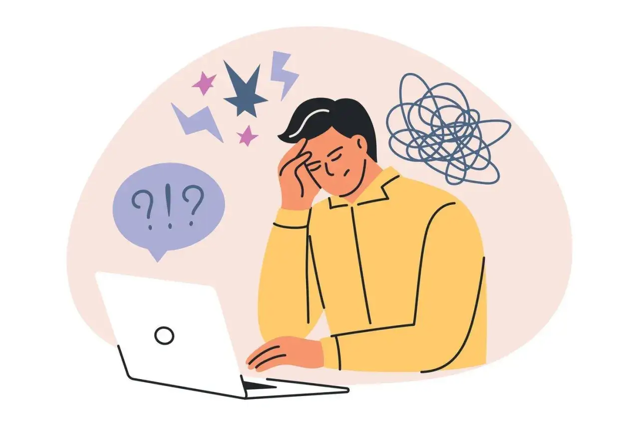 En person med stress och ångest sitter vid en laptop, med huvudet i handen och tankar som virvlar runt.