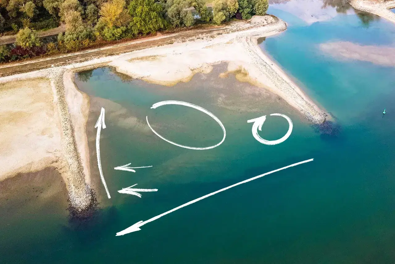 Luftaufnahme einer Sandbank in der Elbe mit wei&szlig;en Pfeilen und Kreisen, die Str&ouml;mungen oder Angelpl&auml;tze markieren.