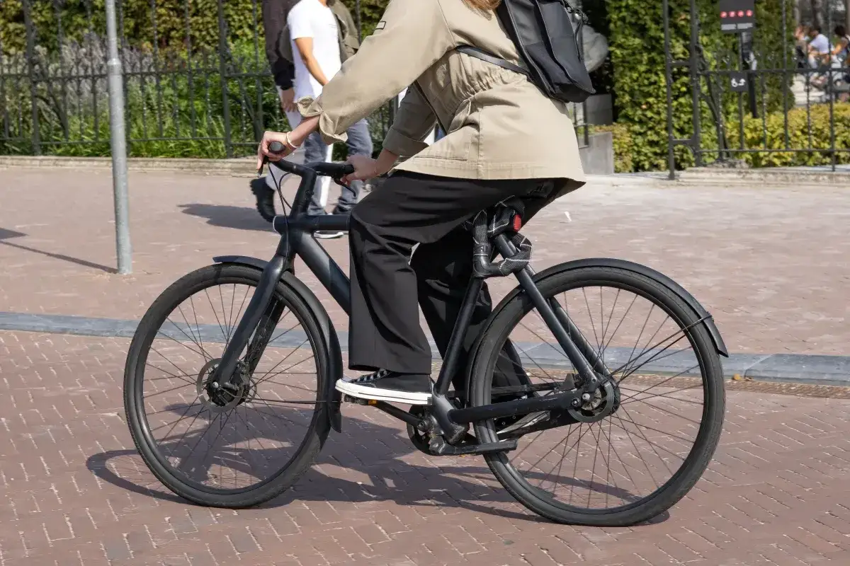 Osoba na czarnym rowerze elektrycznym, idealnym dla każdego, kto szuka ekologicznego transportu. Dofinansowanie do roweru elektrycznego dla kogo? Dla Ciebie!