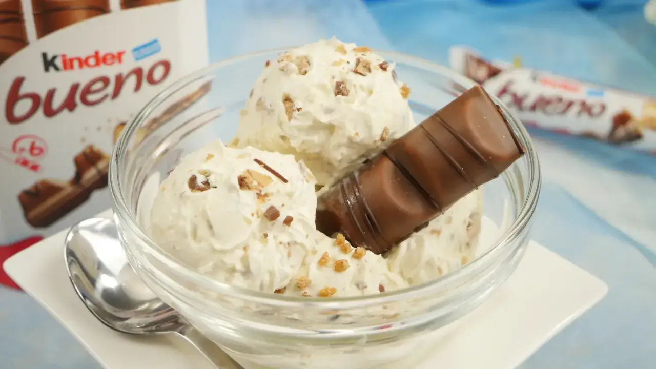 Schüssel mit cremigem Kinder Bueno Eis, garniert mit einem Stück Schokoriegel und knusprigen Stückchen.