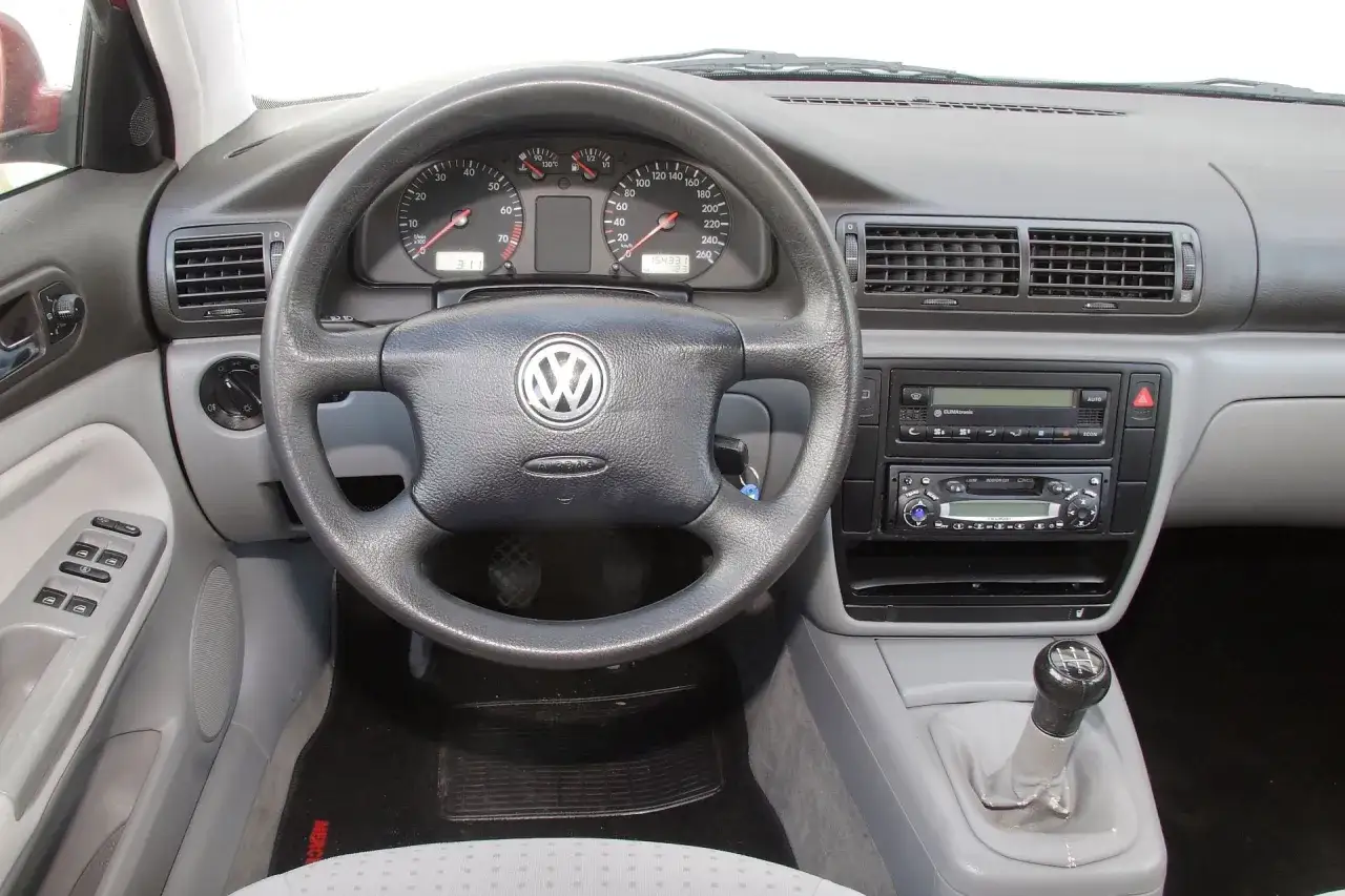 Wnętrze samochodu z kierownicą VW, deską rozdzielczą, radiem i dźwignią zmiany biegów. b5.