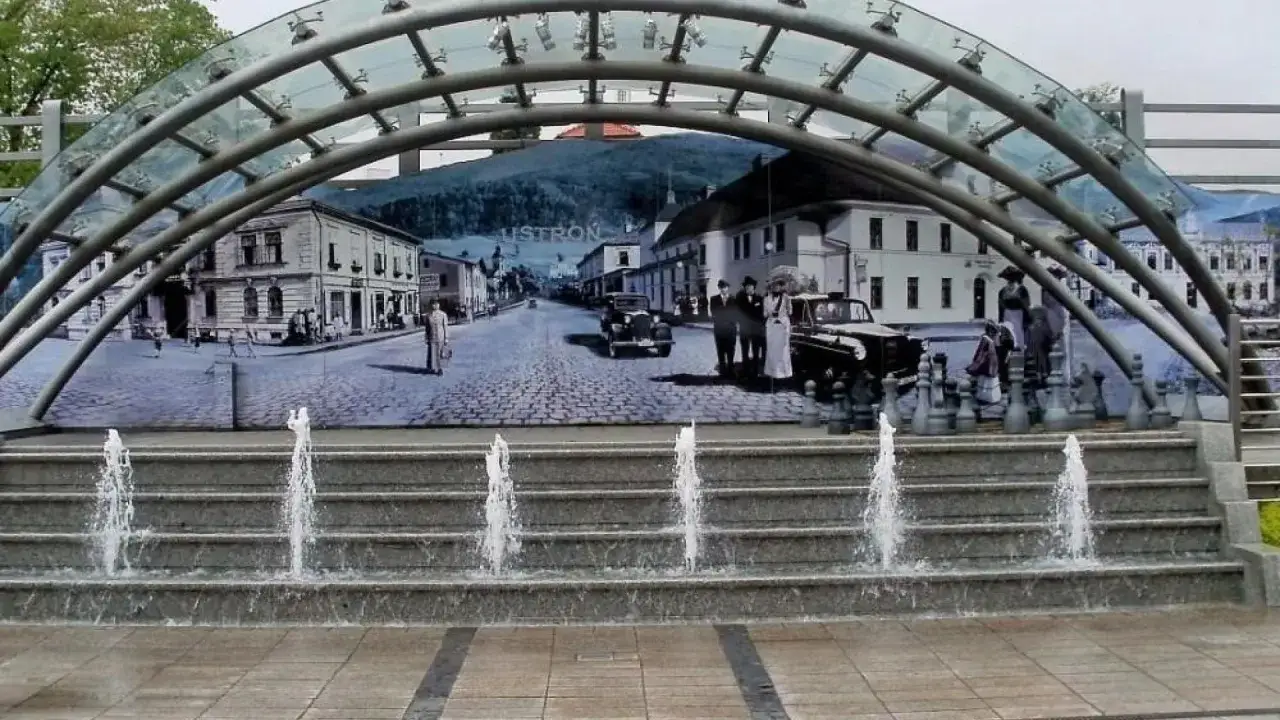 Fontanna przed muralem przedstawiającym ustroń centrum miasta z lat 20. XX wieku.