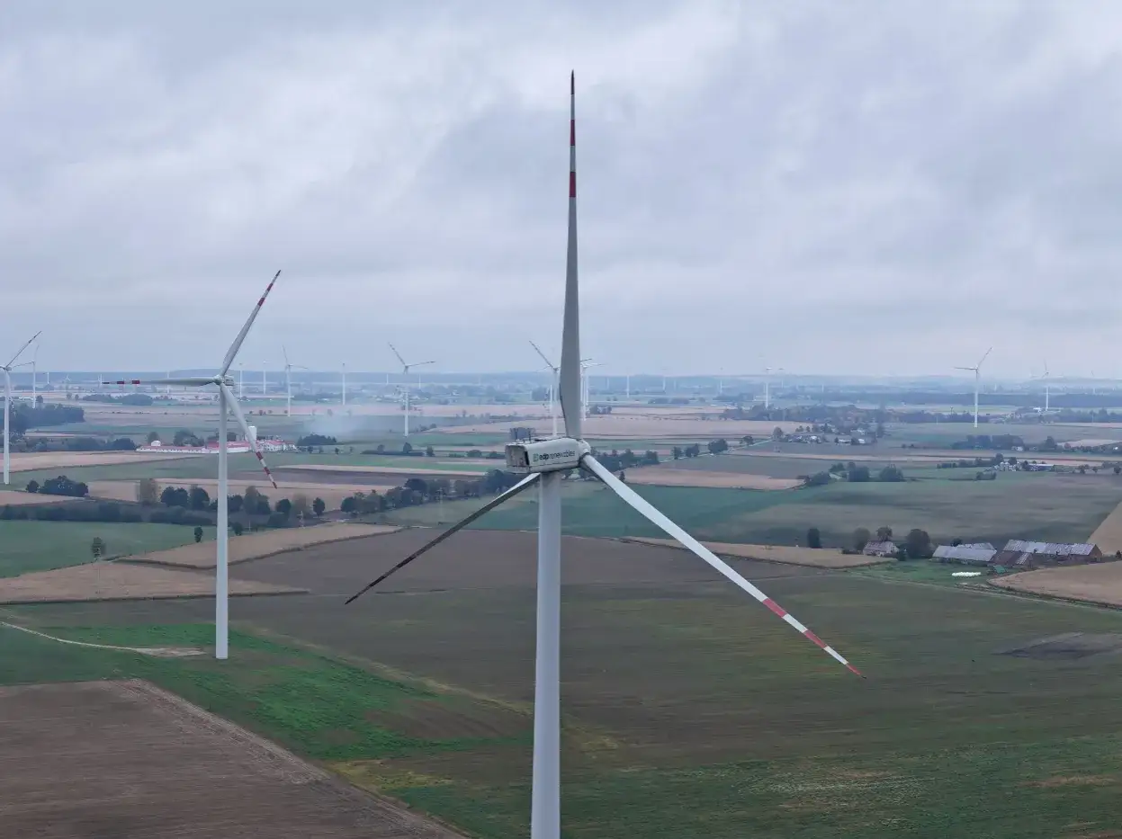 Wiatraki na polu. Zastanawiasz się, ile kosztuje farma wiatrowa? To inwestycja w zieloną energię.
