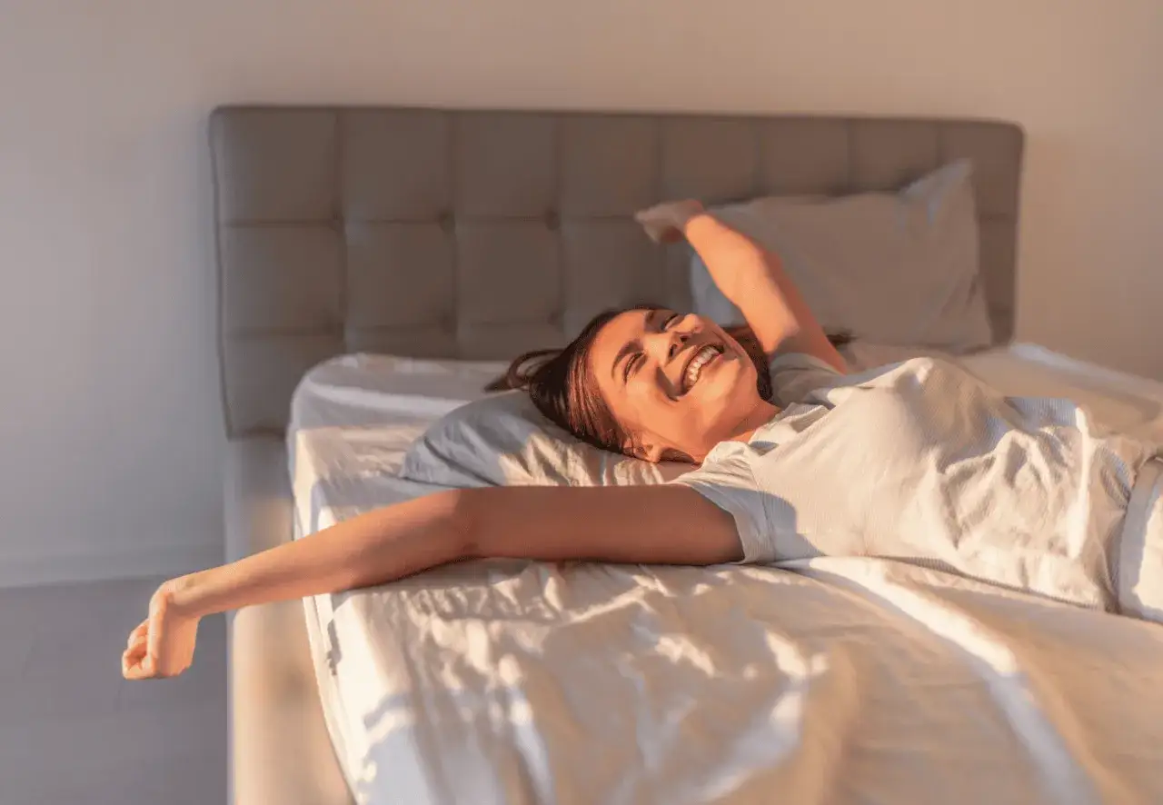 Glückliche Frau streckt sich im Bett. Ob auf einem federkern oder kaltschaum, sie genießt den Morgen.