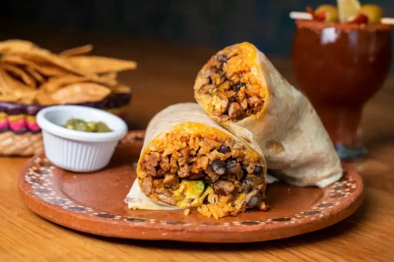 Dwa soczyste burritos z ryżem, fasolą i mięsem. Idealne jakie przyprawy do burrito? Z dodatkiem guacamole i nachos.