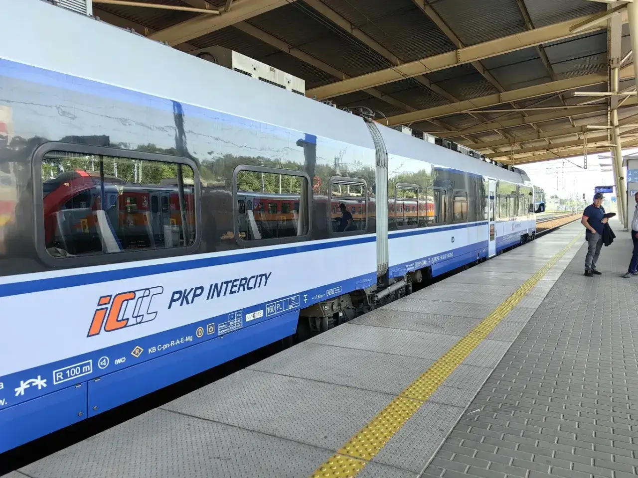 Pociąg PKP Intercity na peronie. Gdzie kupić bilety TLK? Na stacji lub online.