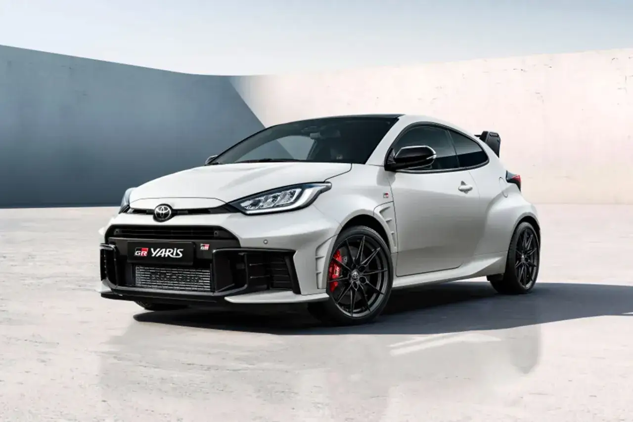 Biały Toyota GR Yaris z czarnymi felgami i czerwonymi zaciskami hamulcowymi, gotowy do akcji.