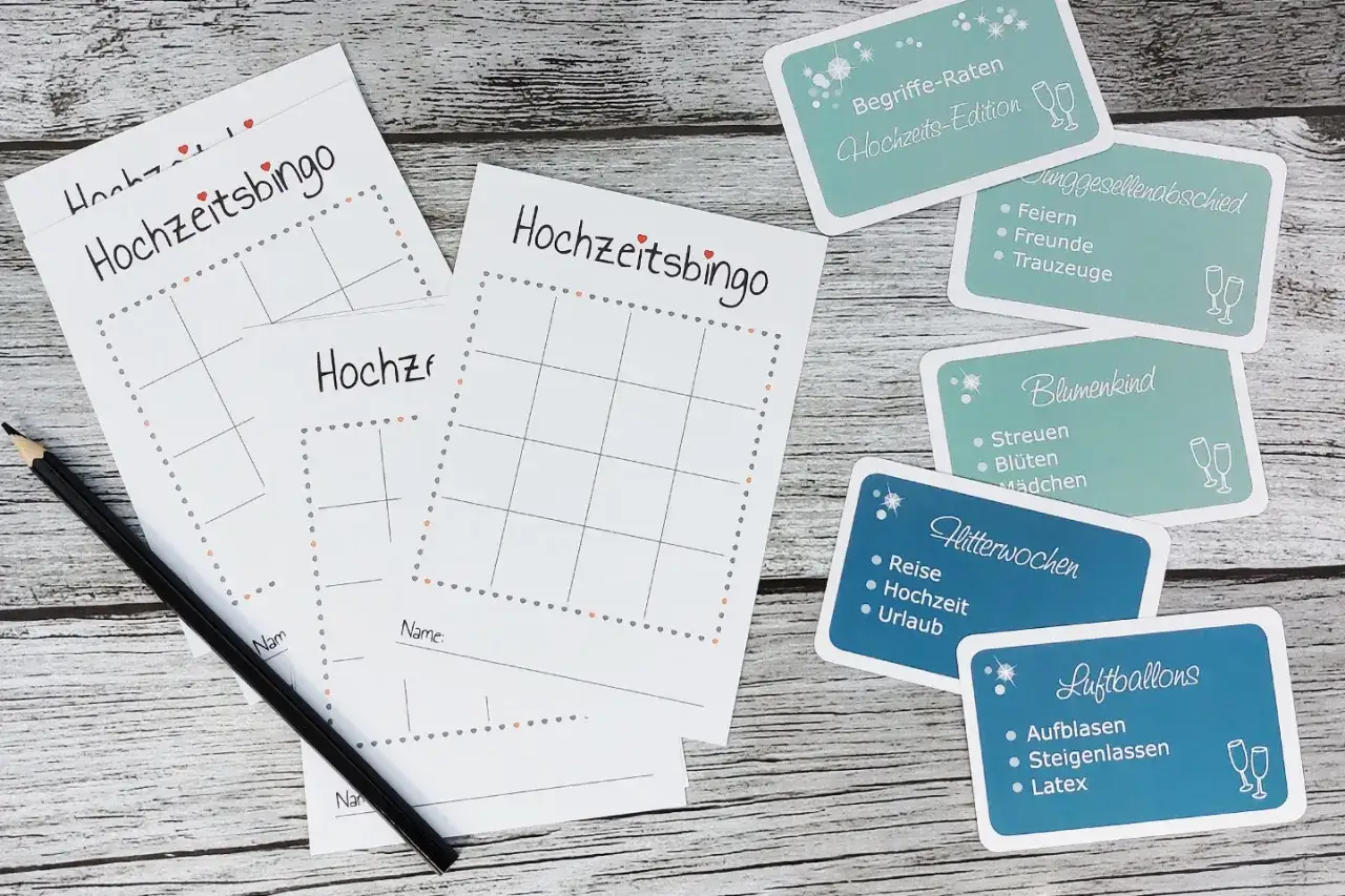 Hochzeitsbingo-Karten und thematische Karten für Spiele zur Hochzeit, wie Junggesellenabschied und Flitterwochen. Ein Bleistift liegt bereit.