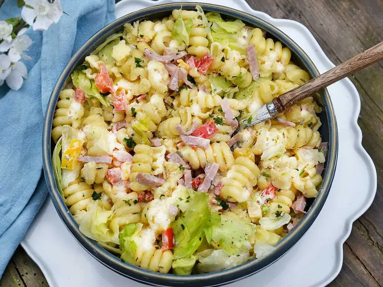 En stor skål med krämig pastasallad med skinka, paprika och sallad. Perfekt dressing till pastasallad för en sommarlunch.