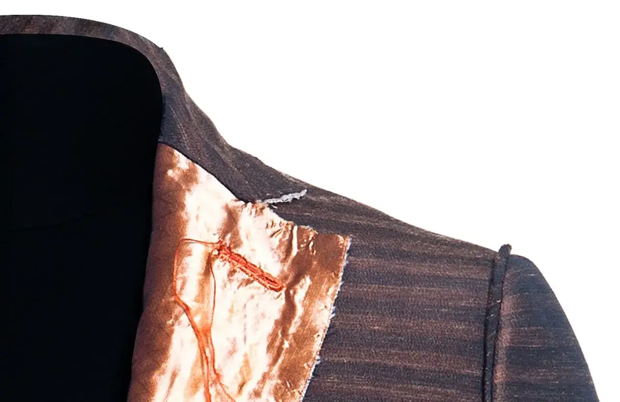 Dettaglio di una giacca destrutturata Armani con fodera color rame e cuciture a vista.