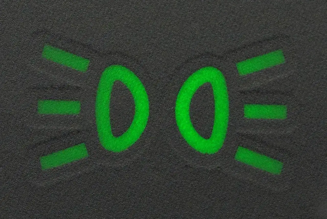 Zielony symbol świateł do jazdy dziennej na ciemnym tle.