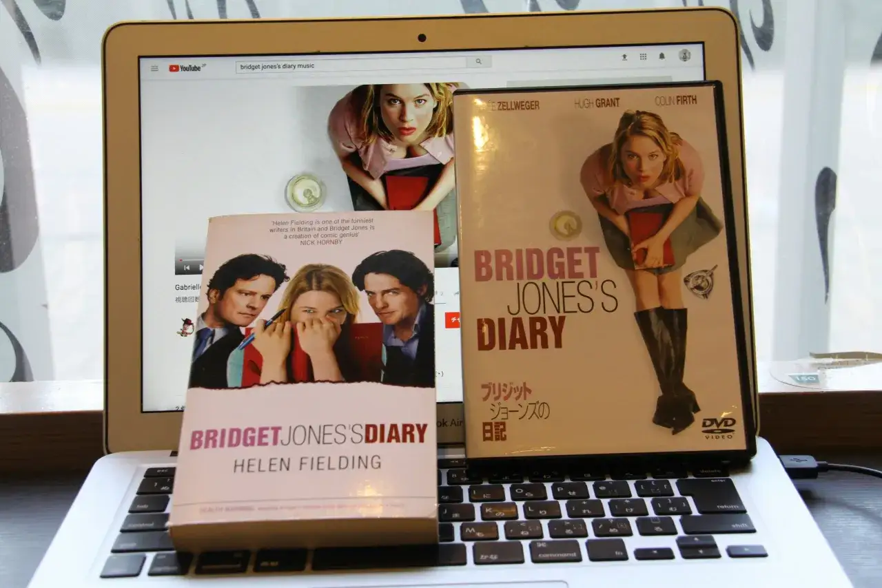 Bridget Jones's Diary: książki i film na laptopie. Ren&eacute;e Zellweger, Colin Firth i Hugh Grant w kultowej historii.