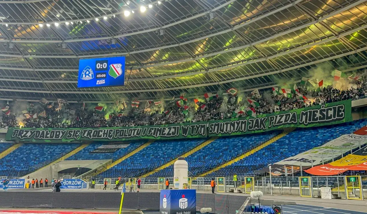 Tłum ultrasi na stadionie, flagi, race i transparent z napisem 