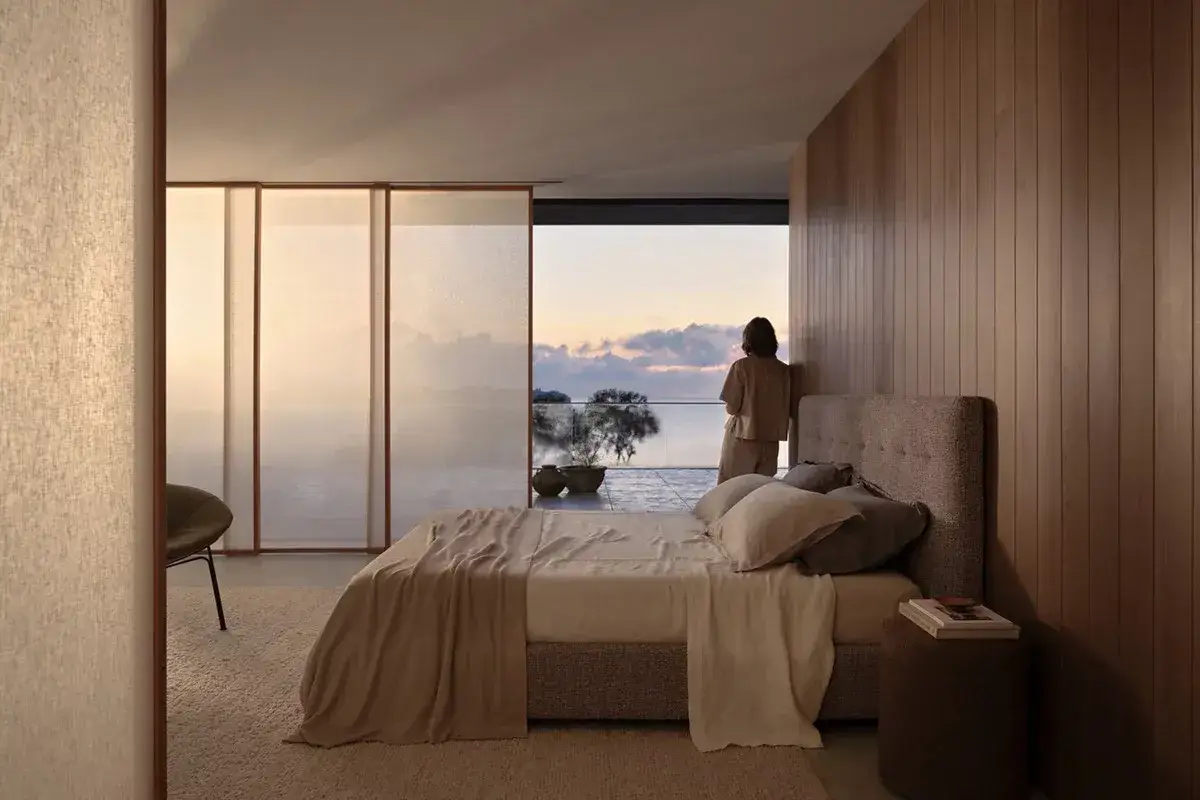 Habitaci&oacute;n con cama y vista al mar al atardecer. A pesar de ser habitaciones muy peque&ntilde;as, el dise&ntilde;o maximiza el espacio y la luz natural.