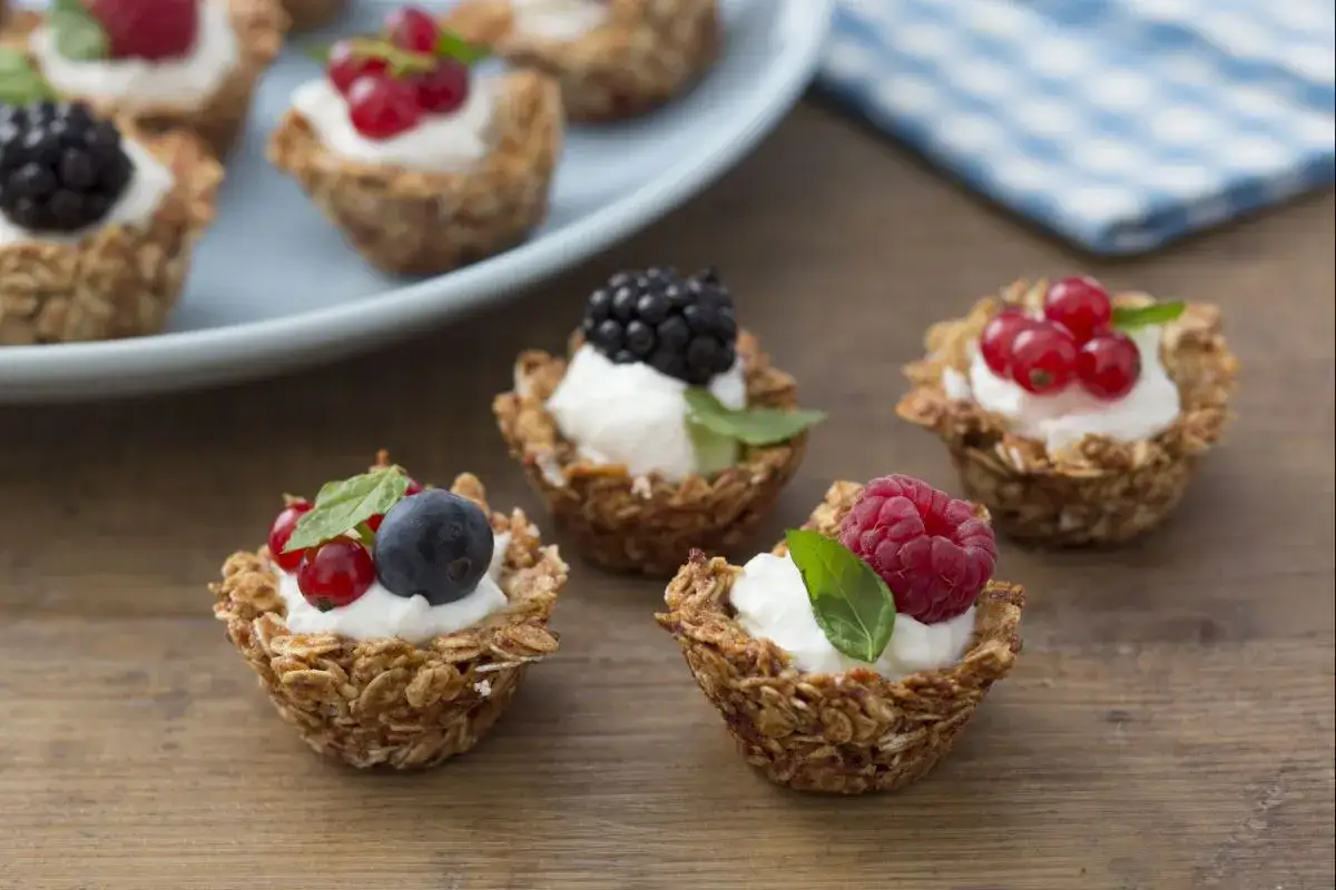 Deliciosas tartas de frutas saludables con base de granola y crema, coronadas con frambuesas, moras, ar&aacute;ndanos y grosellas.