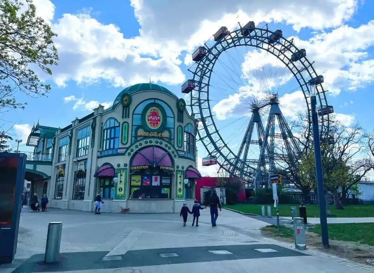 Una famiglia passeggia verso la ruota panoramica del Prater, un'attrazione iconica per chi visita Vienna con i bambini.