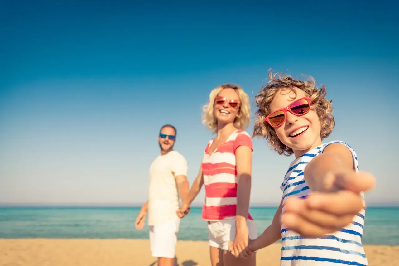 Szczęśliwa rodzina na plaży, idealne wczasy nad morzem z wyżywieniem dla rodzin z dziećmi. Słońce, morze i uśmiechy!