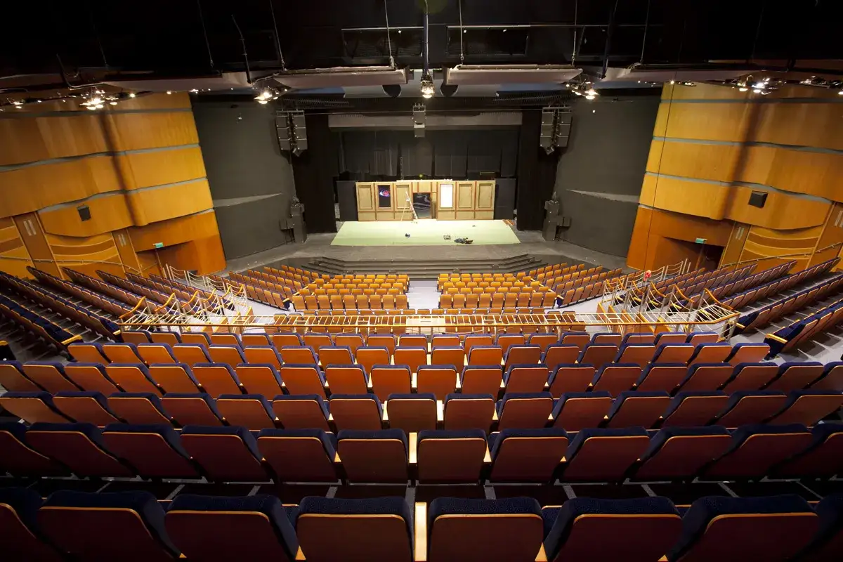 Pusta widownia Teatru Muzycznego im. Danuty Baduszkowej. Pomarańczowe fotele czekają na widz&oacute;w.