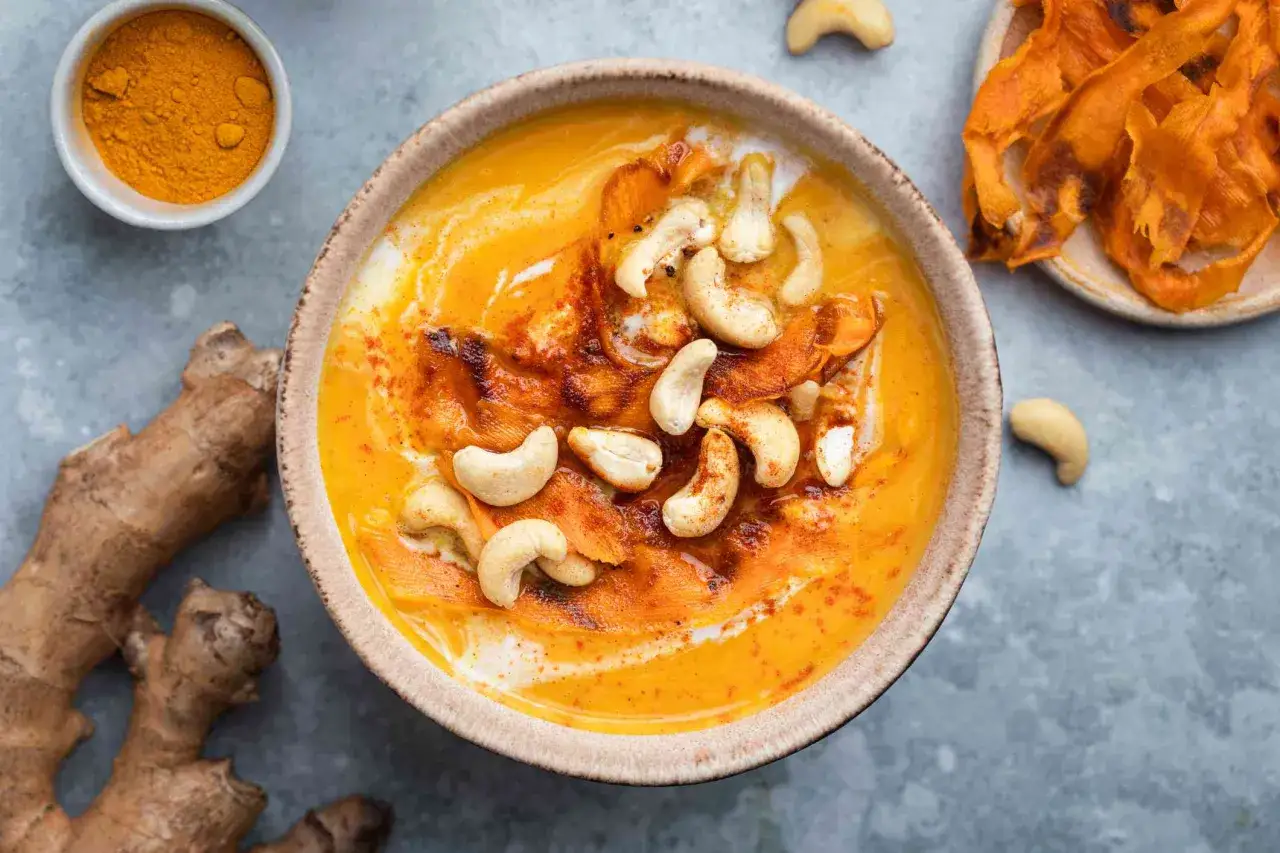 Cremige Suppe mit Kurkuma, Ingwer und Cashewkernen. Die goldenen Gewürze und die cremige Textur laden zum Genießen ein.