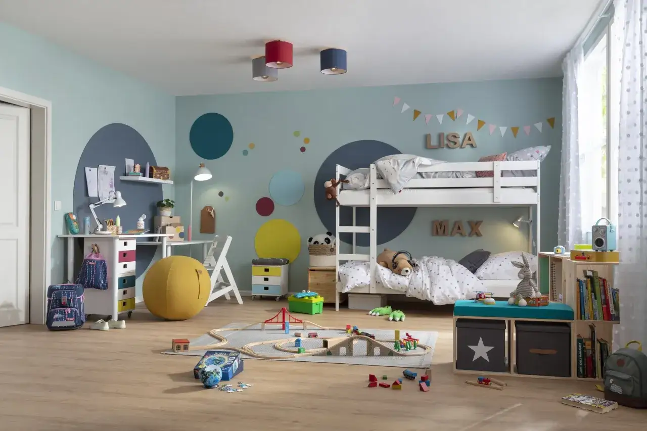 Moderne kinderzimmer wandgestaltung mit Kreisen und Namen. Ein Etagenbett, Spielzeug und ein Schreibtisch machen das Zimmer komplett.