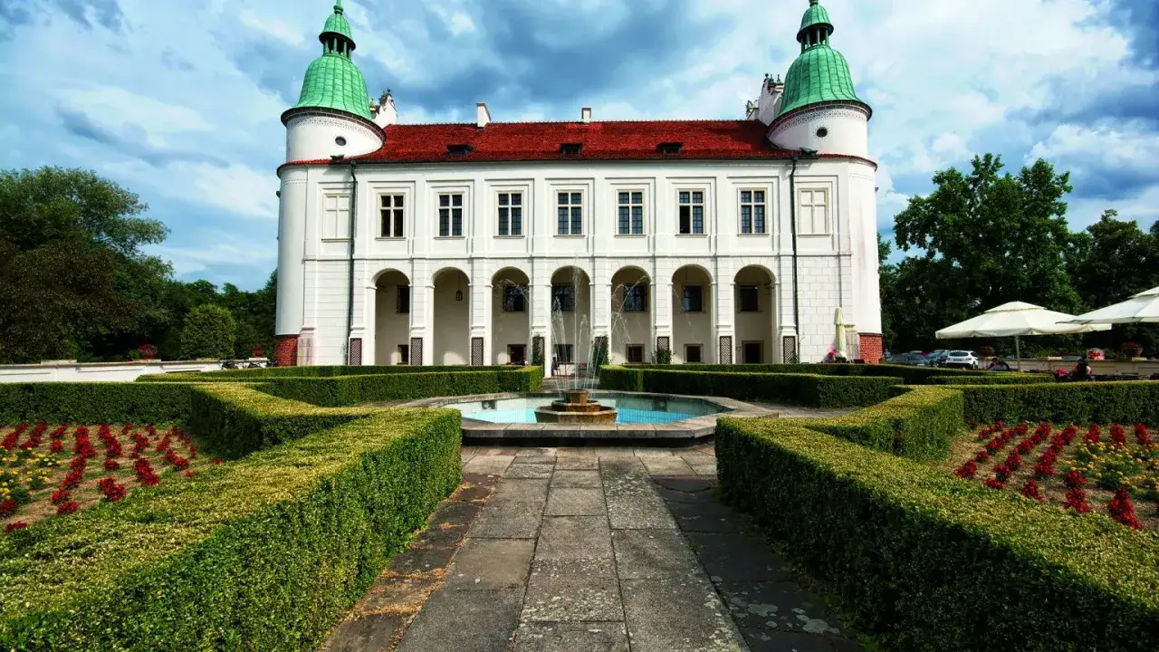 Pałac w stylu renesansowym z fontanną i geometrycznym ogrodem.